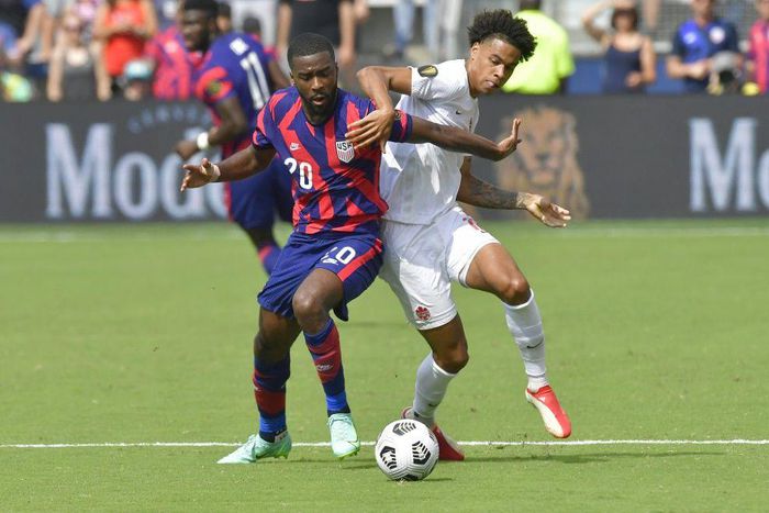 US defender Shaquell Moore, left, and Canada forward Tajon Buchanan battle for the ball during their CONCACAF Gold Cup match in Kansas City, Kansas