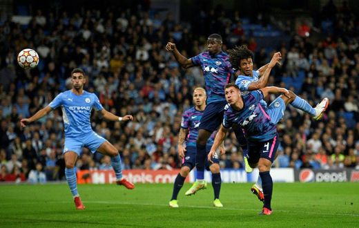 Tinged with sadness: Manchester City's Dutch defender Nathan Ake  jumps to head the ball home
