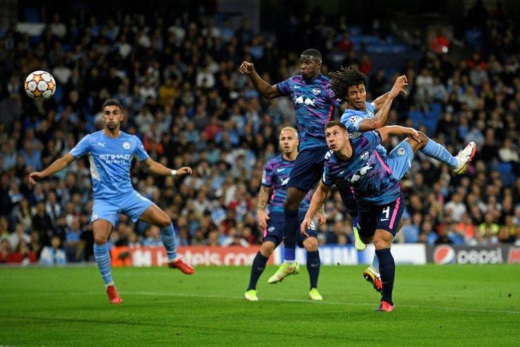 Tinged with sadness: Manchester City's Dutch defender Nathan Ake  jumps to head the ball home