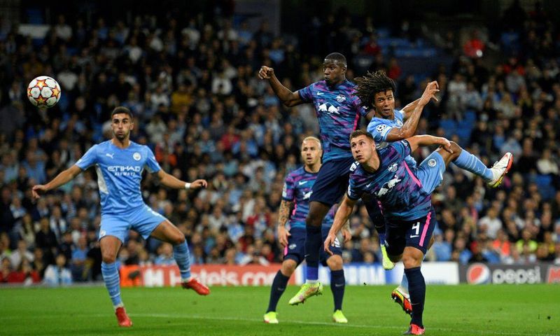 Tinged with sadness: Manchester City's Dutch defender Nathan Ake  jumps to head the ball home