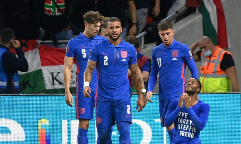 England's forward Raheem Sterling (R) celebrates his opening goal, with a cup thrown by Hungary fans in the background