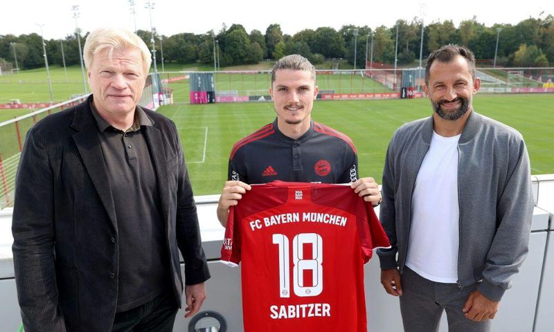 Bayern Munich new signing Marcel Sabitzer (C) flanked by club CEO Oliver Kahn (L) and sports director Hasan Salihamidzic (R)