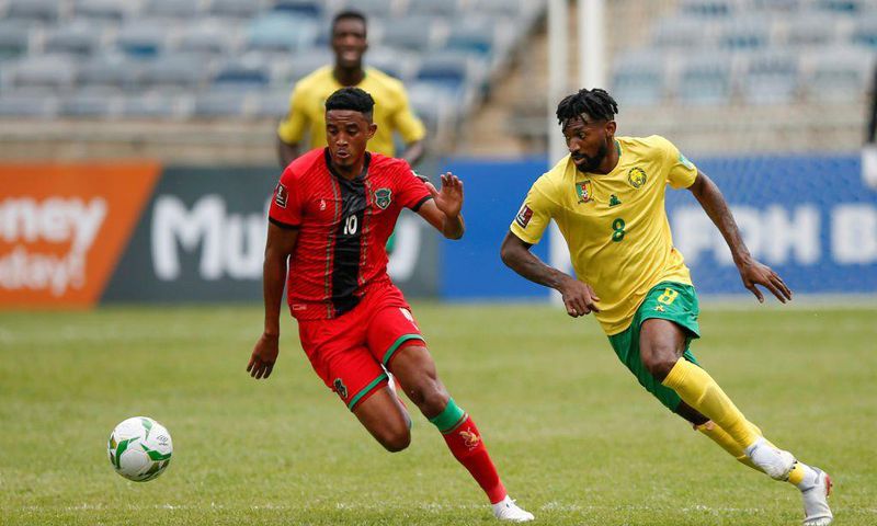 Andre-Frank Zambo Anguissa (R) of Cameroon and Gerald Phiri (L) of Malawi seek possession during a 2022 World Cup qualifier in Soweto on Saturday.