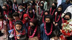 The team wore garlands and dressed in burqas as they arrived at the Pakistan Football Federation in Lahore