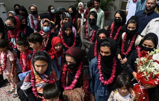 The team wore garlands and dressed in burqas as they arrived at the Pakistan Football Federation in Lahore