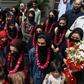 The team wore garlands and dressed in burqas as they arrived at the Pakistan Football Federation in Lahore