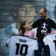 Walter Rotundo, a huge fan of the late Diego Maradona, poses with his daughters Mara (L) and Dona (R)