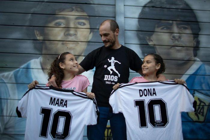 Walter Rotundo, a huge fan of the late Diego Maradona, poses with his daughters Mara (L) and Dona (R)