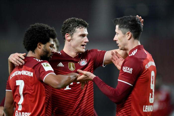 Serge Gnabry (L) and Robert Lewandowski (R) celebrate their goals with Bayern Munich team-mate Benjamin Pavard
