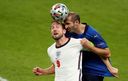 Italy defender Giorgio Chiellini (R) vies for the header with England's Harry Kane