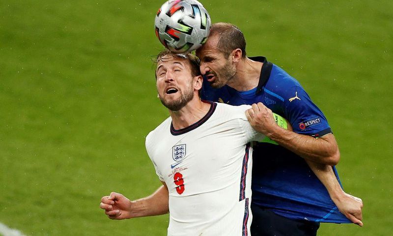Italy defender Giorgio Chiellini (R) vies for the header with England's Harry Kane