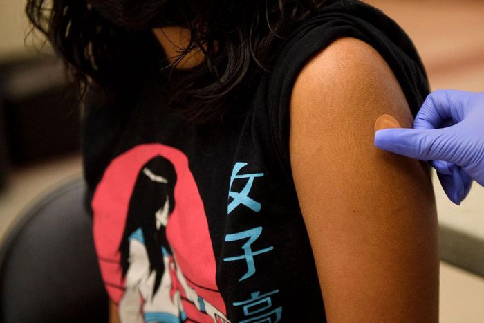 A band-aid is placed on the arm of a 12 year old child after they received a first dose of the Pfizer Covid-19 vaccine after it was approved for use by the FDA in children 12 and over at a Los Angeles County mobile vaccination clinic on May 14, 2021 in...