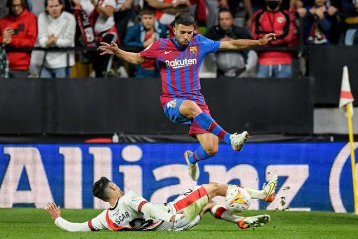 Barcelona defender Jordi Alba jumps over Rayo Vallecano's Oscar Valentin on Wednesday.