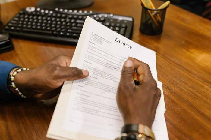 Close-up shot of a person holding divorce papers [Image: RDNE Stock Project]