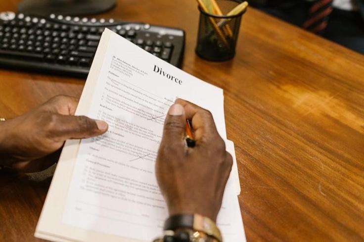 Close-up shot of a person holding divorce papers [Image: RDNE Stock Project]
