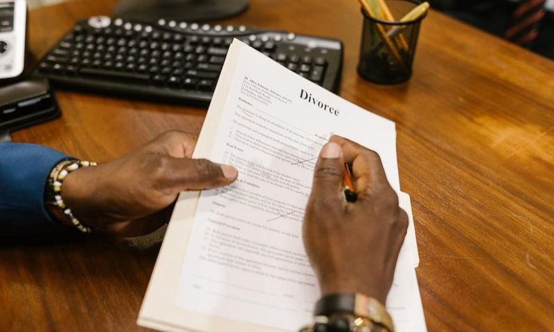 Close-up shot of a person holding divorce papers [Image: RDNE Stock Project]