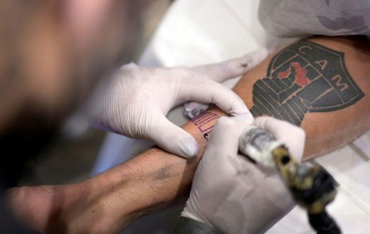 A fan of Brazilian team Atletico Mineiro gets a free tattoo offered by the company constructing the new stadium after the squad won the Brazilian Championship