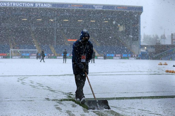 Groundstaff clear snow at Burnley's Turf Moor ground