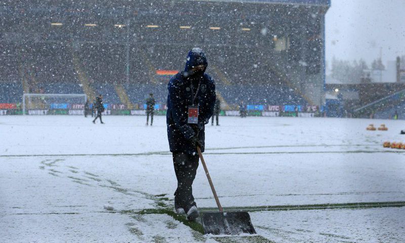 Groundstaff clear snow at Burnley's Turf Moor ground
