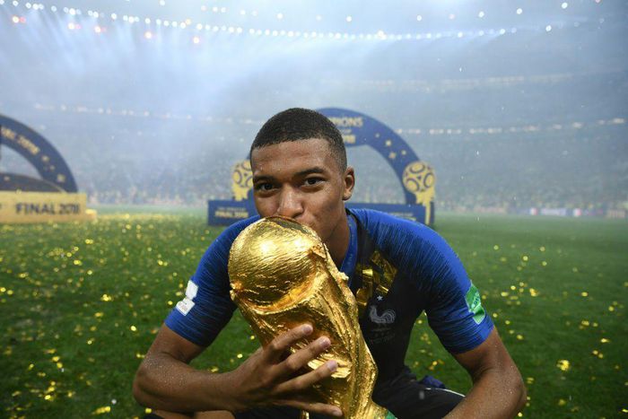France's forward Kylian Mbappe kisses the World Cup trophy after the Russia 2018 World Cup final.