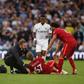 A trainer runs on the pitch to help Liverpool's Harvey Elliott (C)