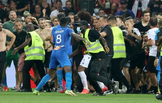 Flash point: Security try to hold back fans as they invade the pitch  at Nice's Allianz Riviera Stadium