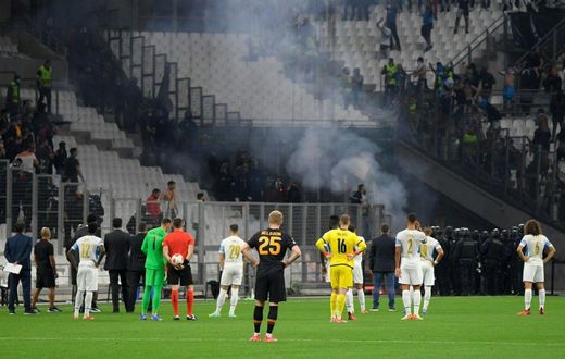Flare for trouble: Players stand on the pitch as the match between Marseille and Galatasaray as held up