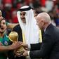 Qatar's Emir Sheikh Tamim bin Hamad al-Thani (C) and FIFA President Gianni Infantino (R) present Algeria's goalkeeper and captain Rais M'Bolhi with the the Arab Cup