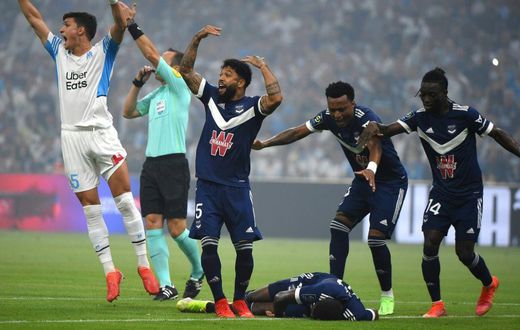 Bordeaux and Marseille's players call for medical help as Samuel Kalu lies on the ground