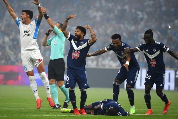 Bordeaux and Marseille's players call for medical help as Samuel Kalu lies on the ground