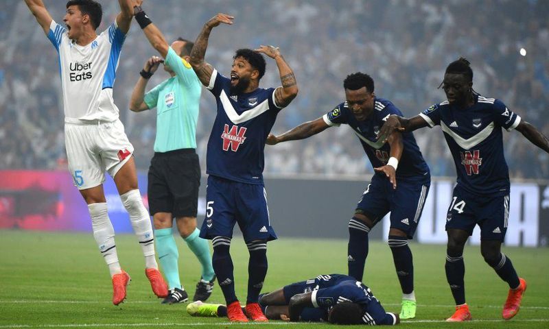 Bordeaux and Marseille's players call for medical help as Samuel Kalu lies on the ground