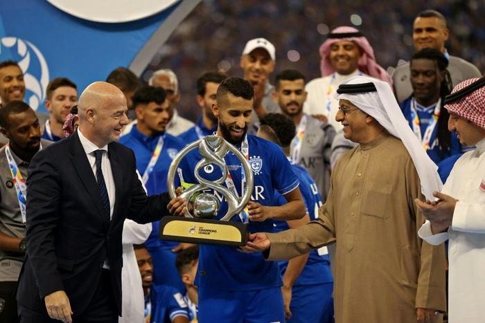 FIFA President Gianni Infantino (left) presents the trophy to Al Hilal midfielder Salman Al-Faraj