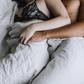 Cropped view of couple spooning in bed