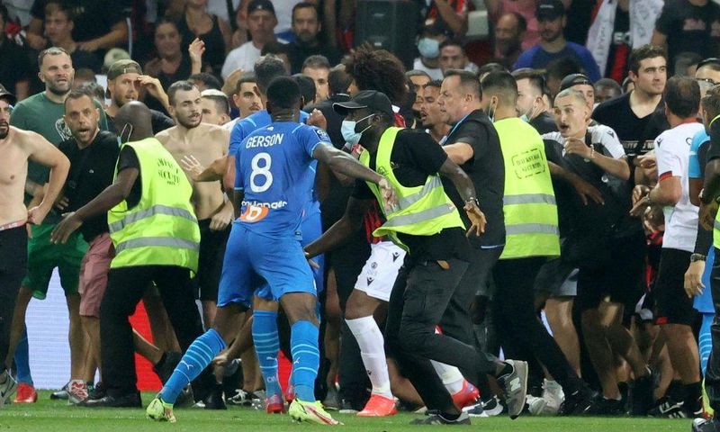 Flash point: Security try to hold back fans as they invade the pitch  at Nice's Allianz Riviera Stadium