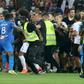 Flash point: Security try to hold back fans as they invade the pitch  at Nice's Allianz Riviera Stadium