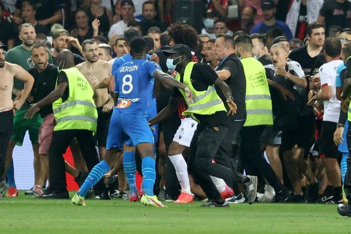 Security try to prevent fans as they invade the pitch during the Marseille's game at Nice