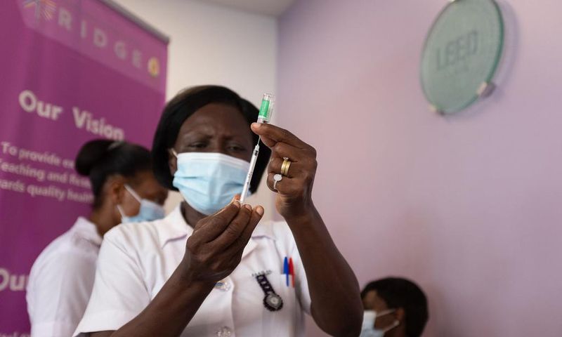 A health worker holds up the AstraZeneca vaccine at the Ridge Hospital in Accra, Ghana, on March 2, 2021.