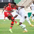 Kenyan Hassan Abdallah (L) shoots under pressure from Ugandan Isaac Muleme (R) during a 2022 World Cup qualifier in Nairobi