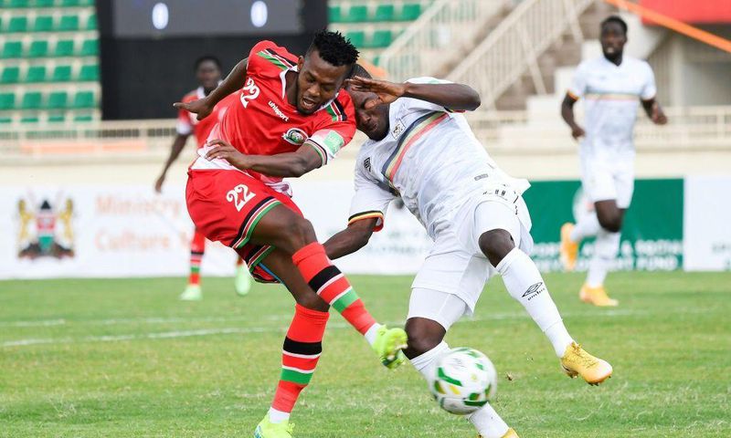 Kenyan Hassan Abdallah (L) shoots under pressure from Ugandan Isaac Muleme (R) during a 2022 World Cup qualifier in Nairobi