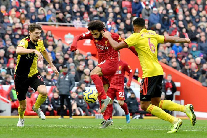 Liverpool star Mohamed Salah (C) shoots as two Watford defenders close in during a Premier League  match at the weekend