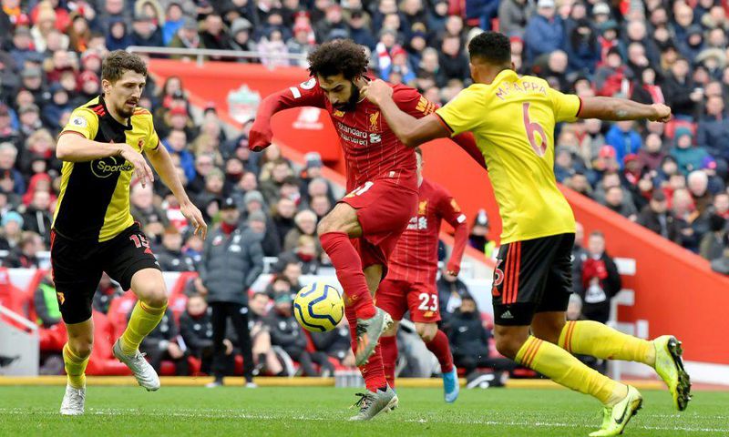 Liverpool star Mohamed Salah (C) shoots as two Watford defenders close in during a Premier League  match at the weekend