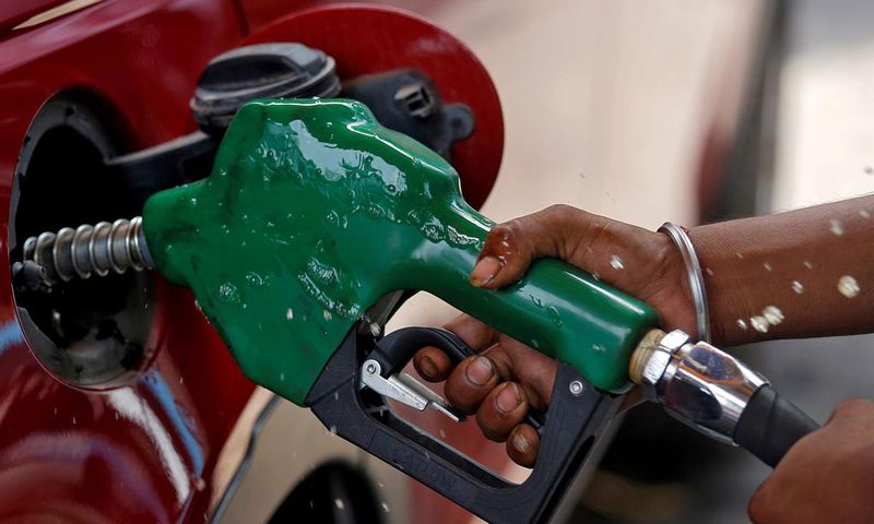 FILE PHOTO: A worker holds a nozzle to pump petrol into a vehicle at a fuel station in Mumbai, India, May 21, 2018. REUTERS/Francis Mascarenhas/File Photo