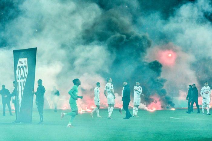 Under fire:Saint-Etienne and Angers players swathed in smoke as kick off was delayed in their Ligue 1 game