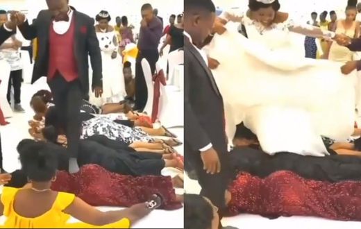 Bride and groom walk on the backs of guests at their wedding reception (video)