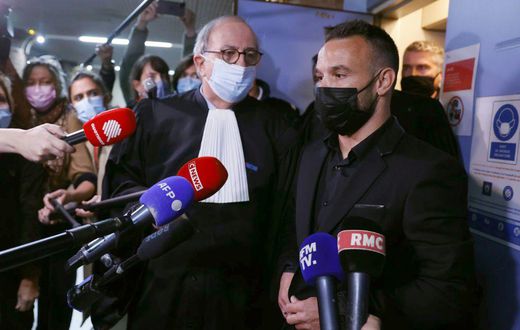 French football player Mathieu Valbuena (R), involved in a 'sex tape case', addresses media representatives next to lawyer Paul Albert Iweins (C) inside a court