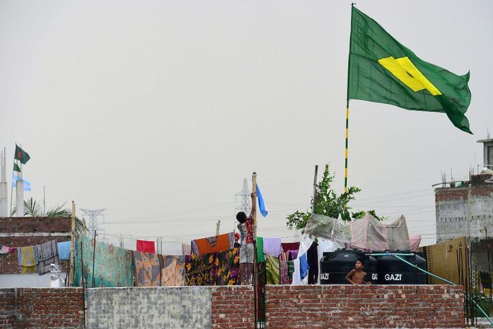 A child hoists the national flag of Argentina on the outskirts of Dhaka during the 2018 World Cup