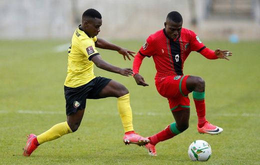 Midfielders Luis Miquissone (L) of Mozambique and John Banda (R) of Malawi contest possession during a World Cup qualifier in Soweto on Tuesday