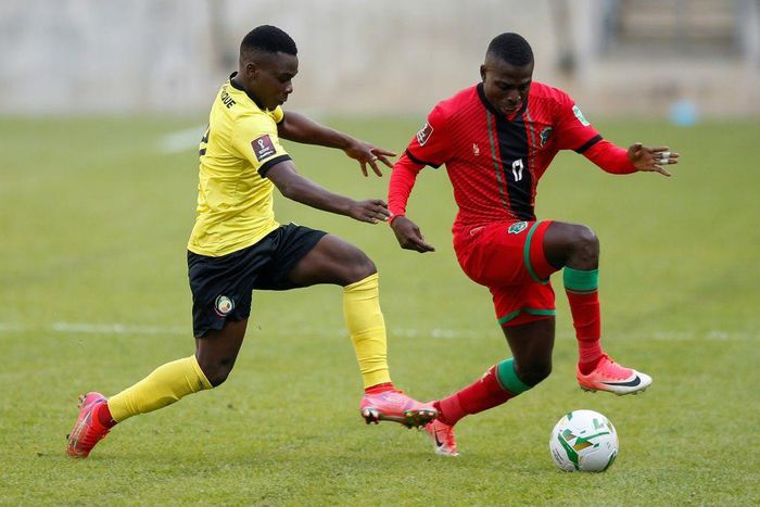 Midfielders Luis Miquissone (L) of Mozambique and John Banda (R) of Malawi contest possession during a World Cup qualifier in Soweto on Tuesday