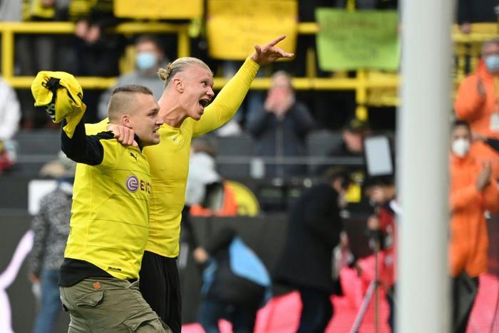 Dortmund striker Erling Braut Haaland celebrates a goal with a fan who invaded  the pitch during their win over Mainz on October 16