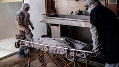 Mortuary workers move the body of a COVID-19 victim at a crematorium in Cuautitlan Izcalli, Mexico State